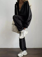 Women's long sleeve zip-up jacket and pants lounge set by Trendsi, plush fabric, casual comfy loungewear ensemble.