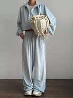 Women's long sleeve zip-up jacket and matching lounge pants set by Trendsi, featuring plush fabric for cozy comfort.