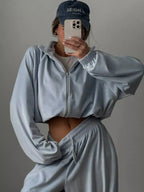 Women’s long sleeve zip-up jacket and matching lounge pants set by Trendsi, plush fabric, casual comfortable loungewear.