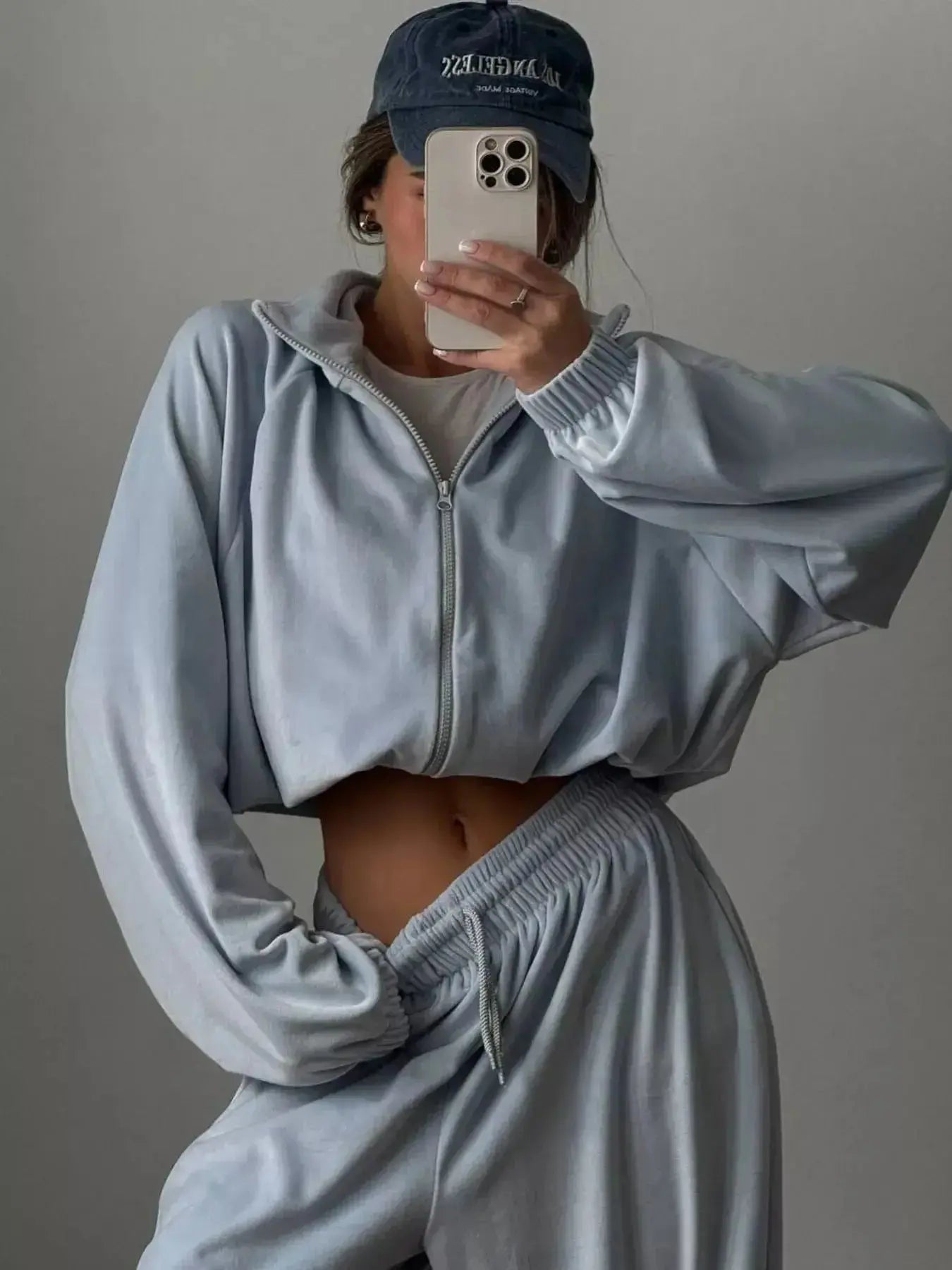Women’s long sleeve zip-up jacket and matching lounge pants set by Trendsi, plush fabric, casual comfortable loungewear.