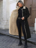 Women's longline denim jacket with cozy sherpa lining, perfect for fall and winter outdoor wear by Trendsi.