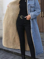 Women’s longline denim jacket with sherpa lining, cozy fall and winter outerwear by Trendsi, featuring classic denim style and warm interior.