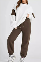 Women's oversized drop shoulder sweatshirt and matching jogger pants, trendy loungewear set by Trendsi, comfortable and casual style.