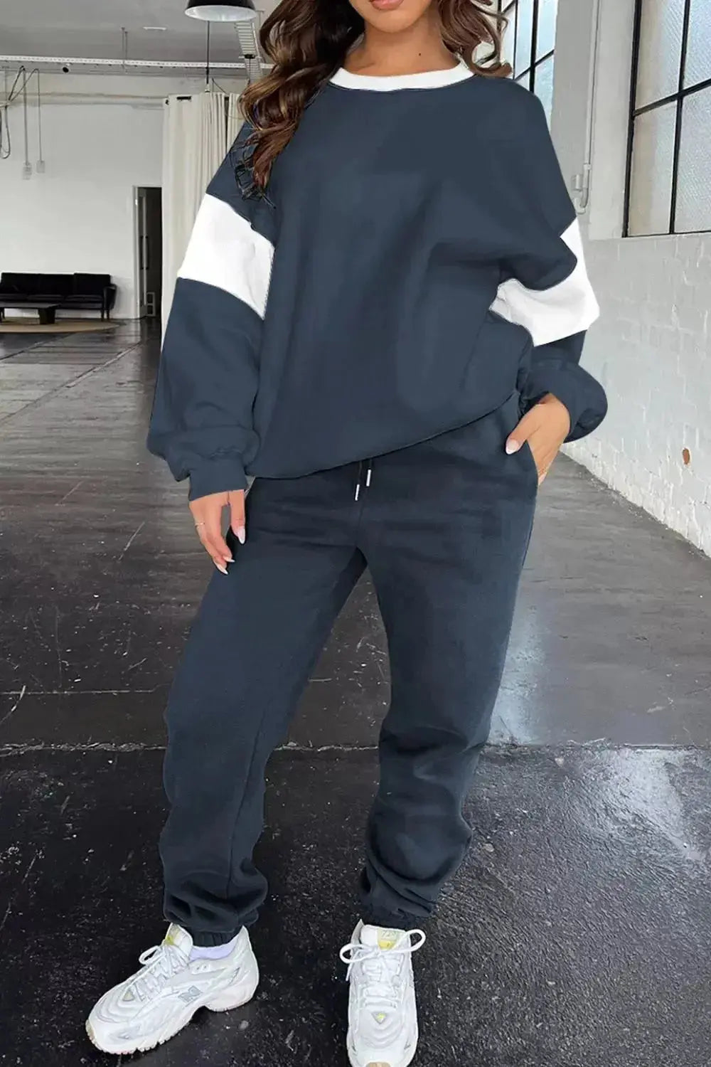 Women wearing oversized drop shoulder sweatshirt and matching joggers from Trendsi loungewear set, casual and comfortable.