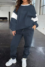 Women wearing oversized drop shoulder sweatshirt and matching joggers from Trendsi loungewear set, casual and comfortable.