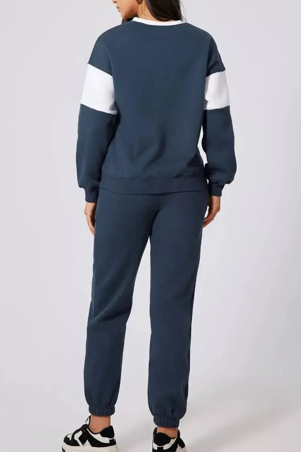 Women wearing oversized drop shoulder sweatshirt and matching joggers loungewear set, stylish and comfortable jogging suit from Trendsi.