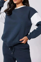 Women wearing oversized drop shoulder sweatshirt and joggers loungewear set by Trendsi, casual and comfortable athleisure outfit.