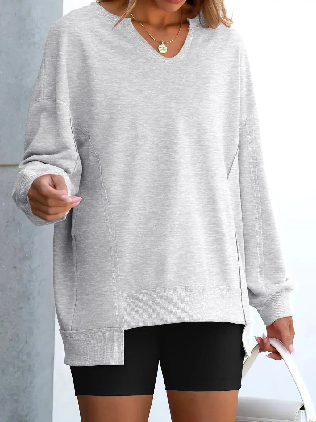 Women’s oversized notched neck sweatshirt with contrast stitching, trendy sweater from Trendsi, displayed on a model.