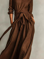 Plus size women's long sleeve maxi dress with tie waist and pockets from Trendsi, featuring a flowing silhouette and comfortable fit.