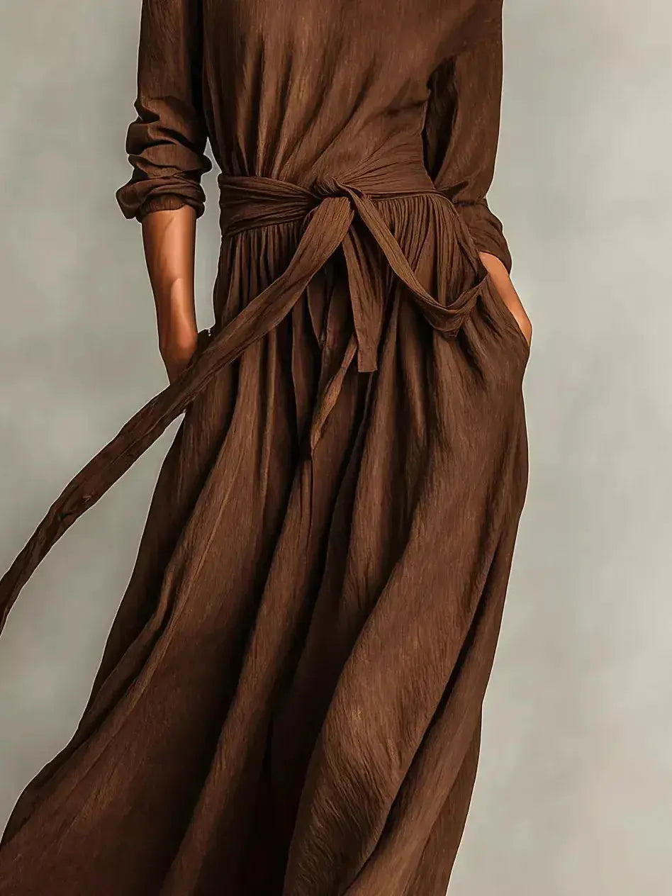 Plus size women's long sleeve maxi dress with tie waist and pockets from Trendsi, featuring a flowing silhouette and comfortable fit.