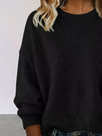 Plus size women's relaxed fit sweater with dropped shoulders and round neck, by Trendsi, displayed on a model.