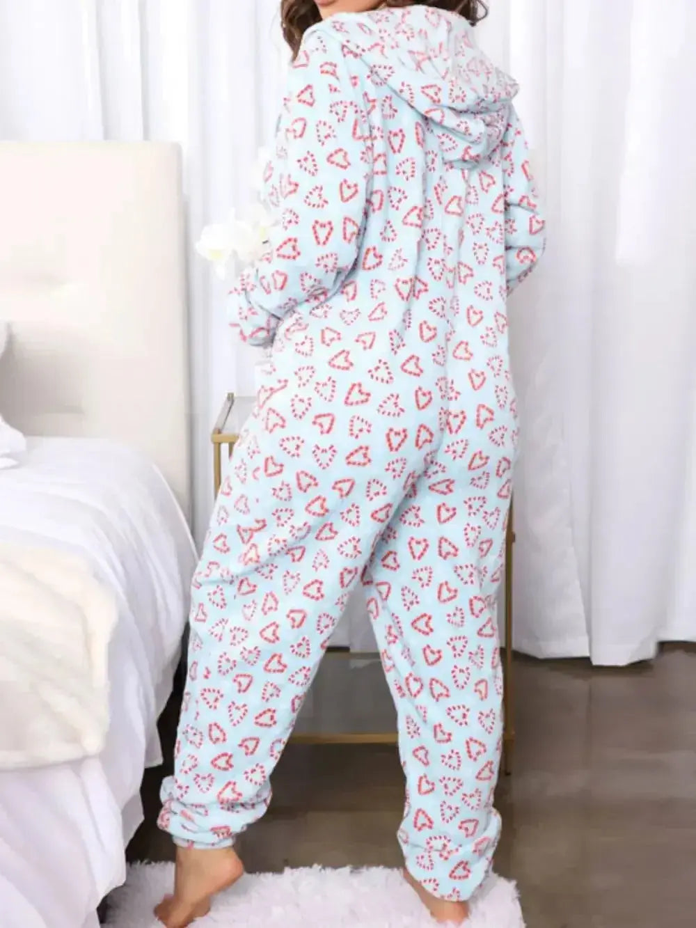 Women’s printed hooded zip-up lounge jumpsuit by Trendsi, cozy one-piece pajamas with a relaxed fit and playful pattern.