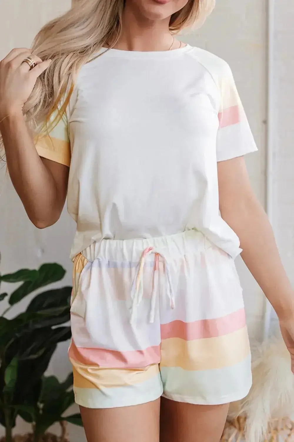 Women's rainbow striped round neck T-shirt and shorts lounge set, casual pajama ensemble by Trendsi, featuring colorful stripes and soft fabric.
