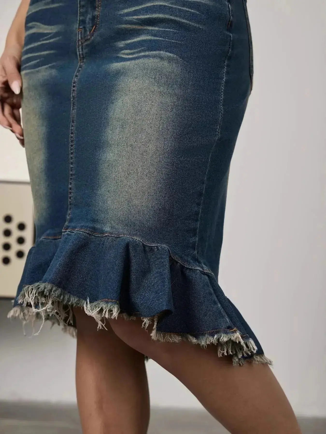 Women’s raw hem mermaid denim midi skirt by Trendsi, showcasing a stretchy blue jean silhouette with a fitted, flared design.