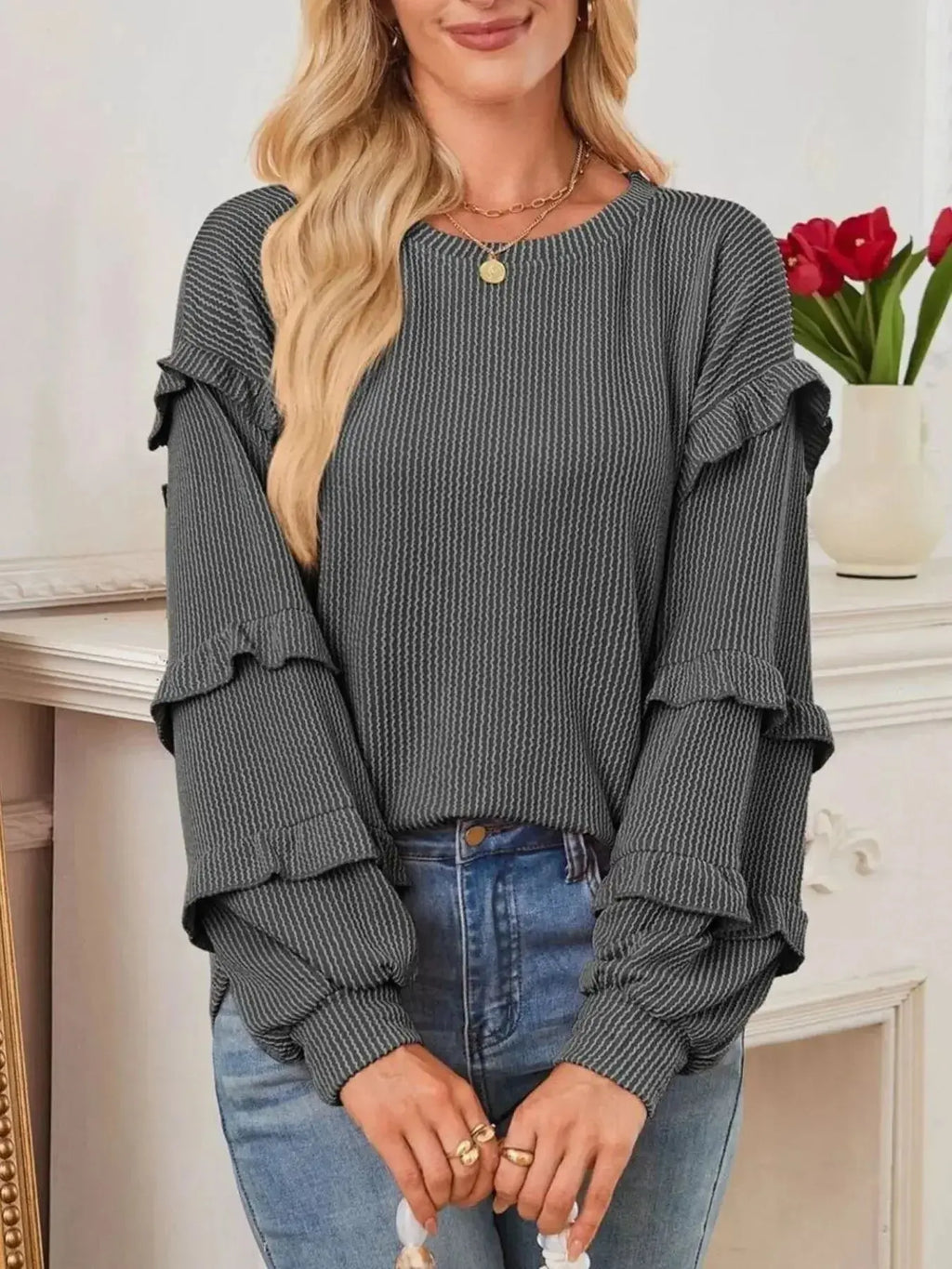 Women's ruffled round neck ribbed long sleeve sweatshirt by Trendsi, featuring a stylish ruffled neckline and cozy ribbed fabric.