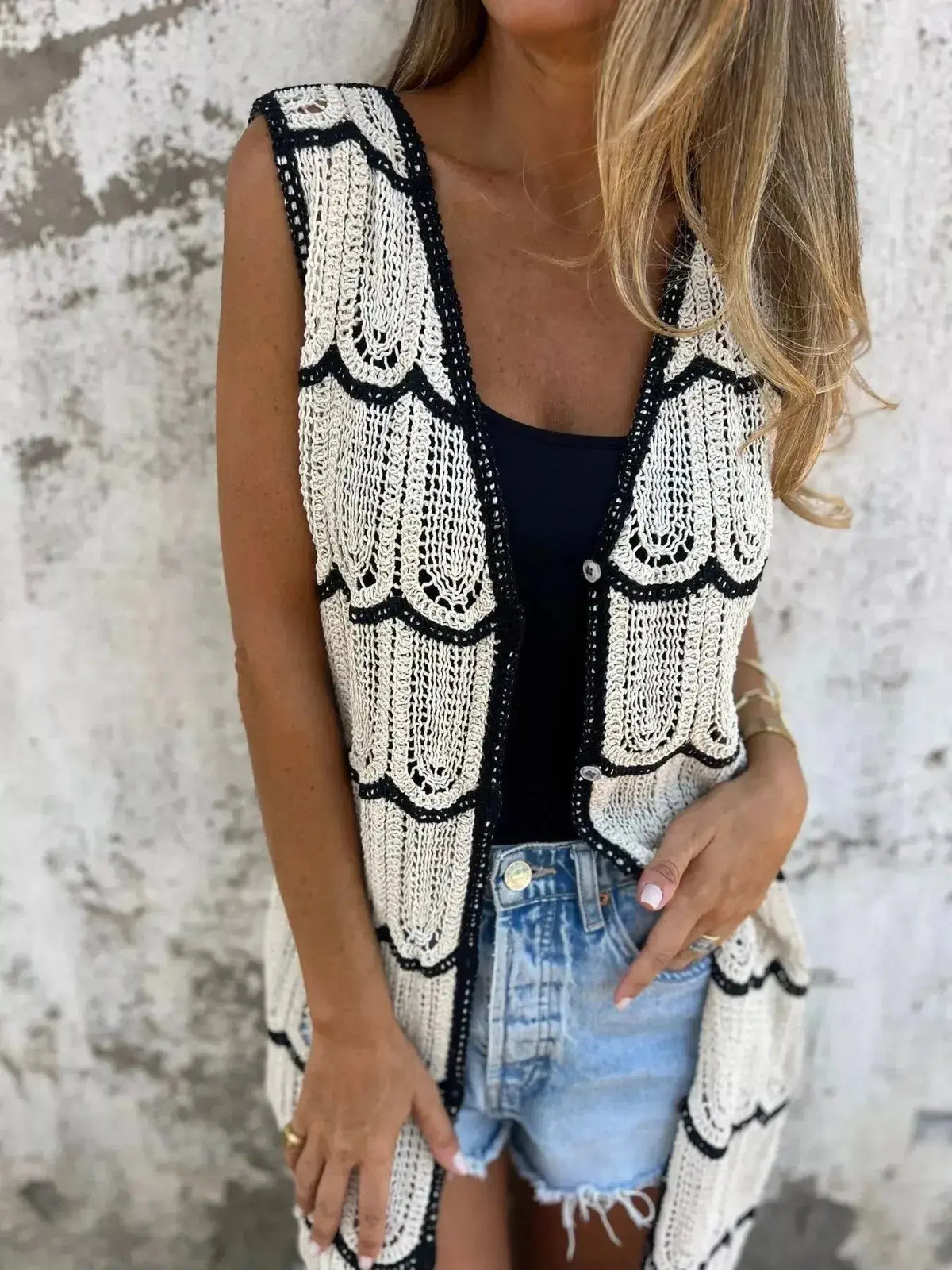 Women’s sleeveless crochet longline cardigan with openwork knit design and button front, stylish vest from Plush Fashion Hub.