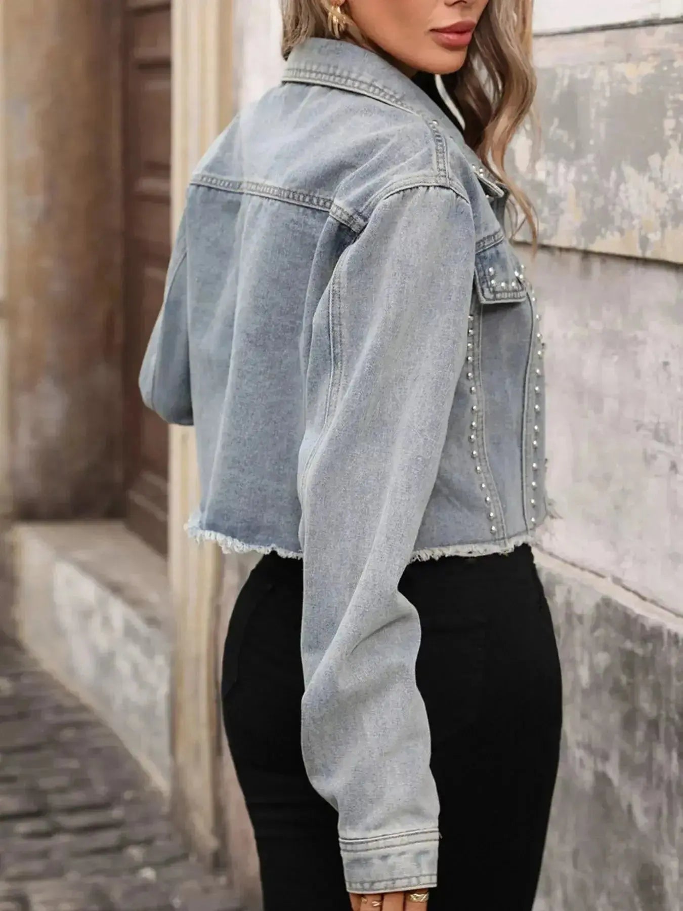 Women’s studded raw hem denim jacket by Trendsi, featuring distressed style, metal stud embellishments, and casual distressed denim look.