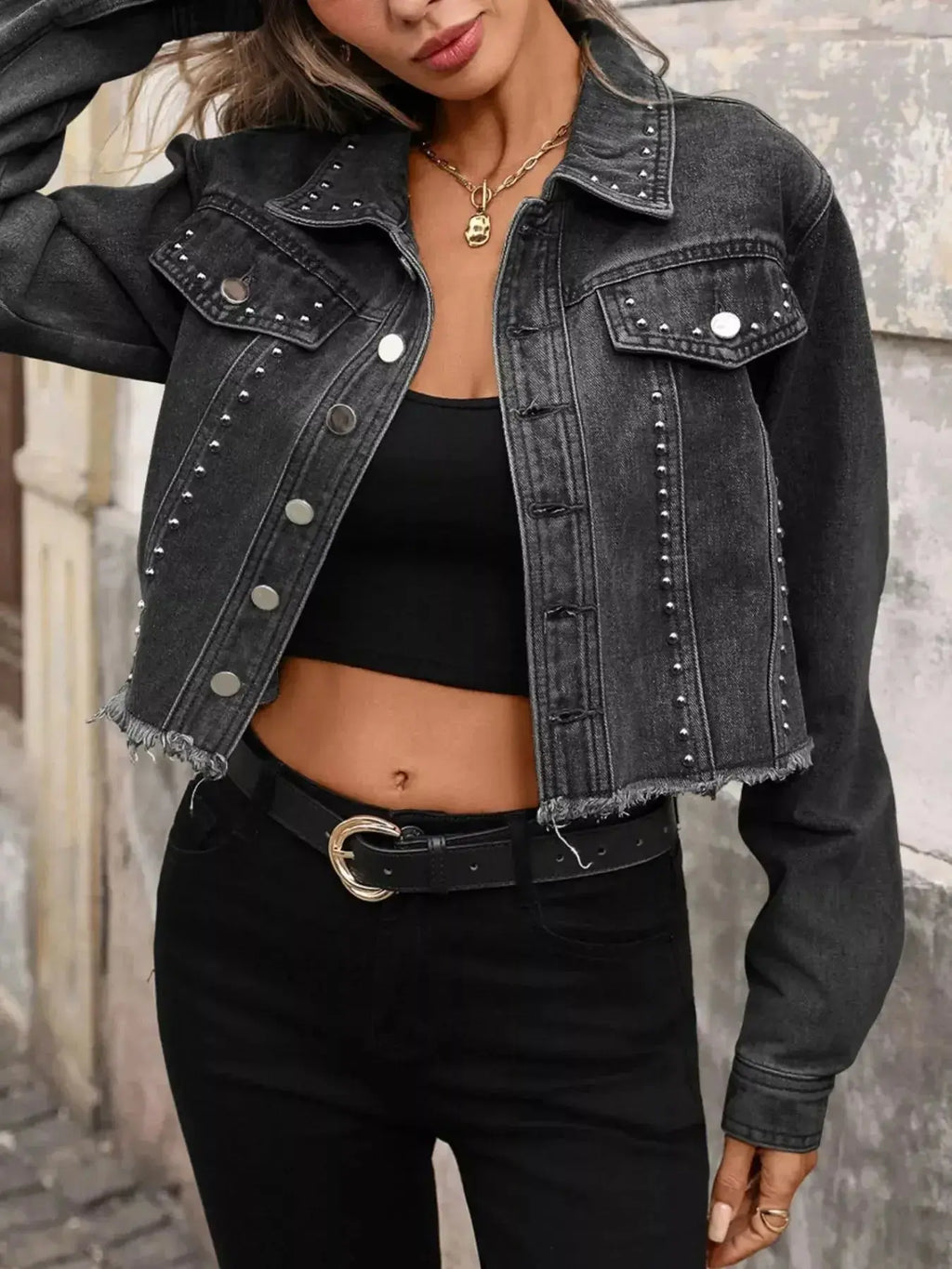 Women’s studded raw hem denim jacket with distressed details, stylish trendy jean jacket by Trendsi, shown on a model.