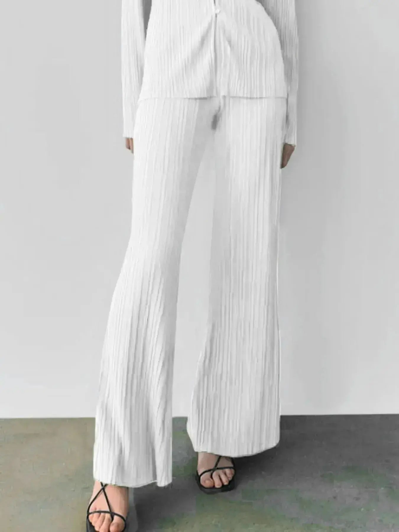 Women's textured long sleeve lounge set with cozy button-up top and matching pants, stylish pajama two-piece from Trendsi.
