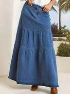 Women's tiered maxi denim skirt with ruched zipper detail, stylish and casual, by Trendsi, shown with flowing fabric and trendy design.