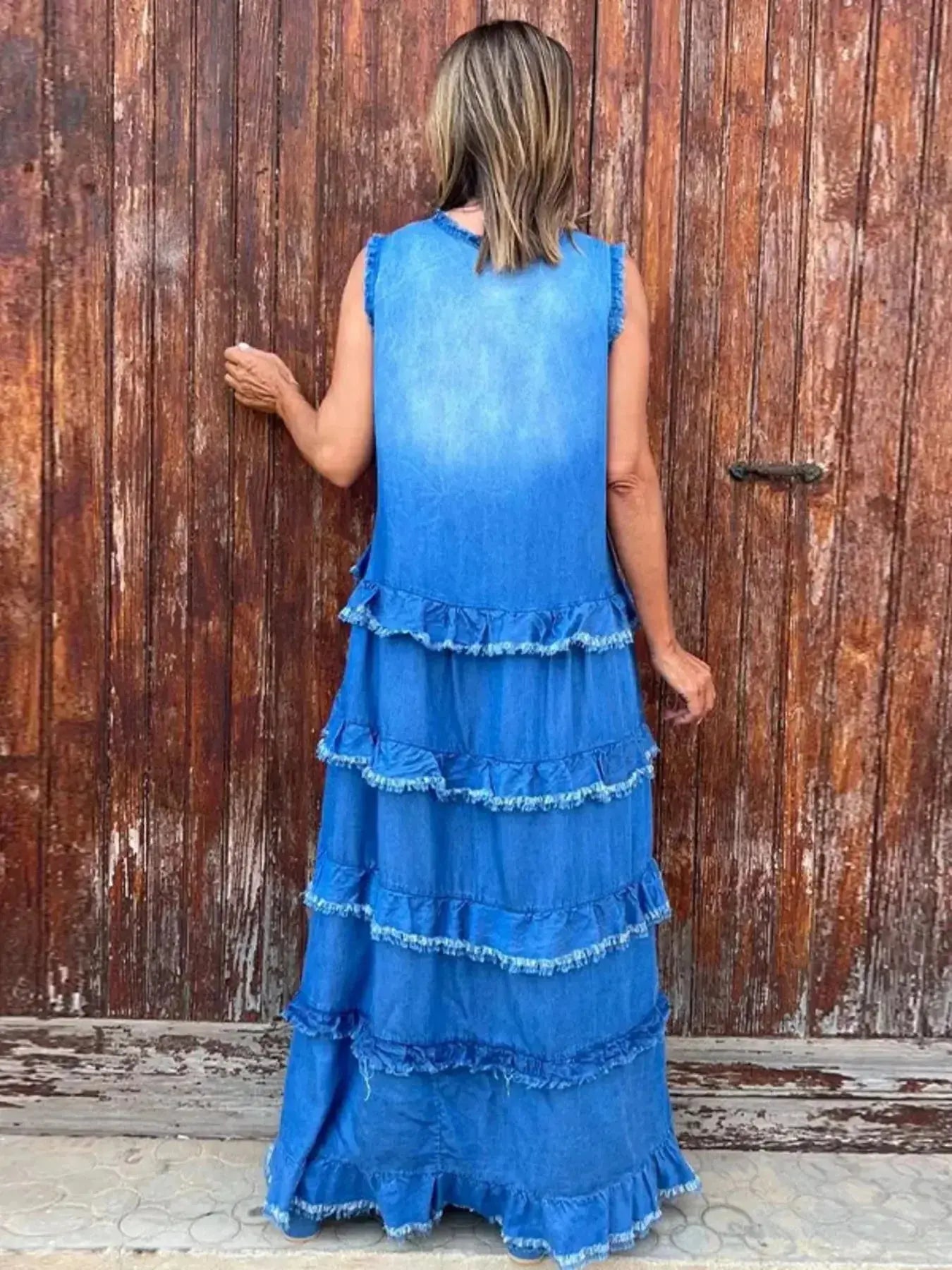 Women’s tiered raw hem denim maxi dress by Plush Fashion Hub, featuring ruffled details and a casual, flowing silhouette.