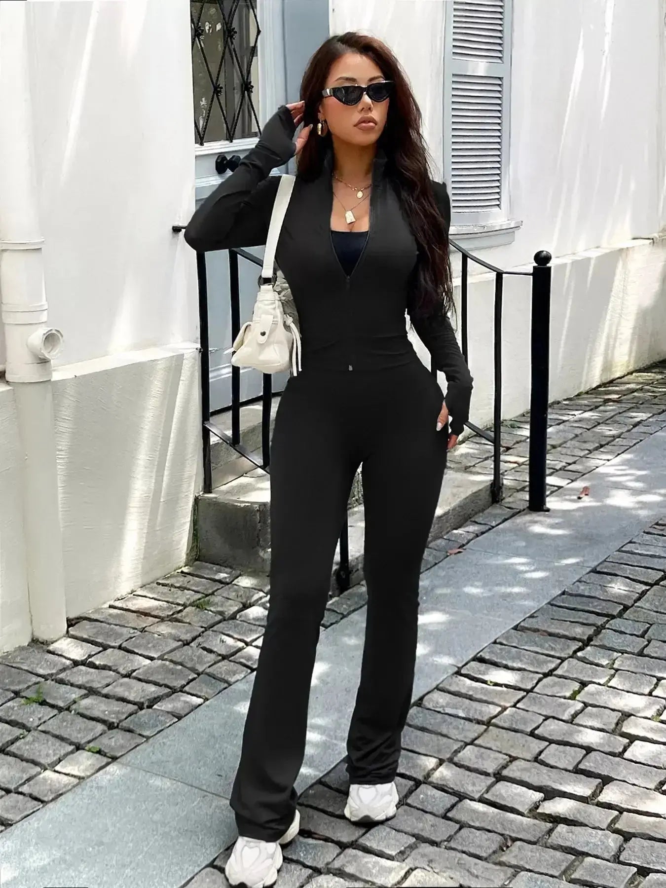 Women's zip-up long sleeve active sweatsuit two-piece set by Trendsi, featuring comfortable fabric and sporty style.