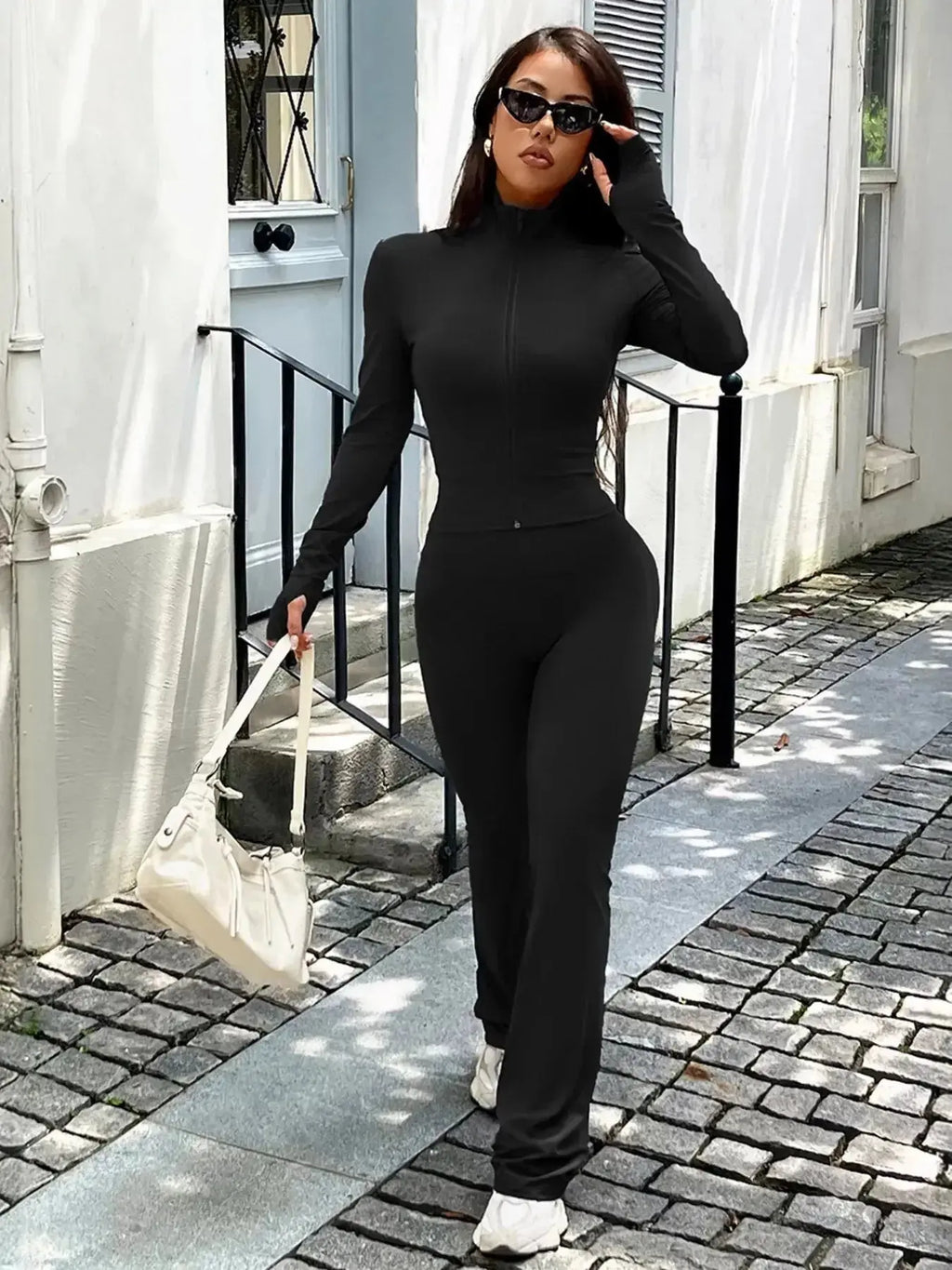 Women’s zip-up long sleeve active sweatsuit two-piece set by Trendsi, featuring a comfortable jacket and matching pants.