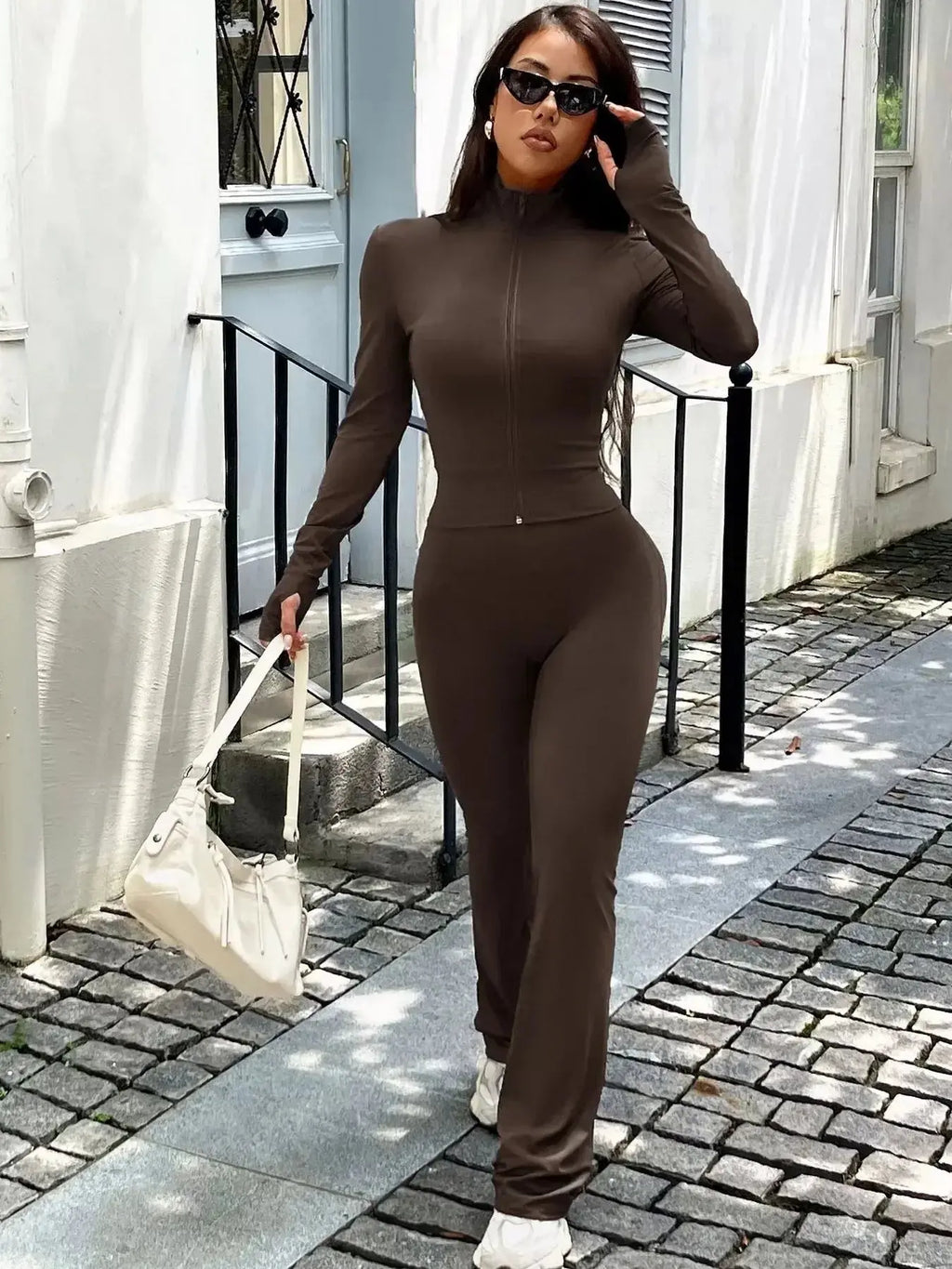 Women’s zip-up long sleeve active sweatsuit two-piece set by Trendsi, featuring a comfortable matching top and bottoms.