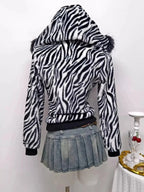 Zebra faux fur hooded zip-up jacket by Trendsi featuring plush texture and black-and-white zebra pattern.