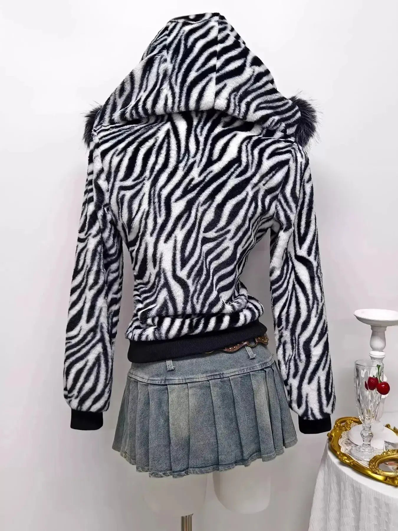 Zebra faux fur hooded zip-up jacket by Trendsi featuring plush texture and black-and-white zebra pattern.
