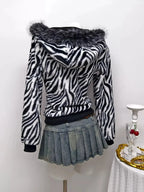 Zebra faux fur hooded zip-up jacket from Trendsi, showing plush black and white zebra print with front zipper and hood.