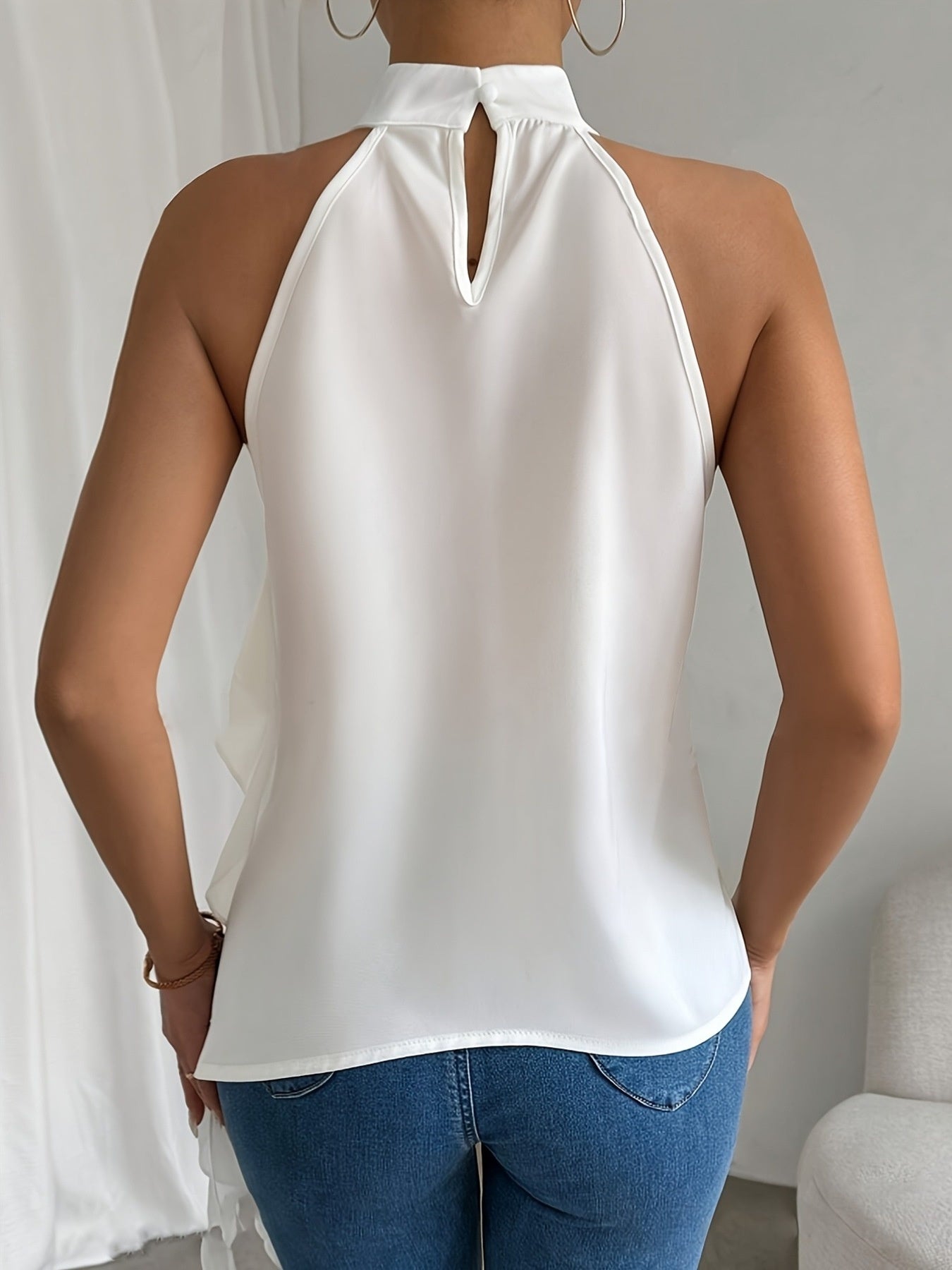Chic ruffle halter neck sleeveless blouse for women, elegant office top by Trendsi, featuring ruffle detailing and a stylish halter design.