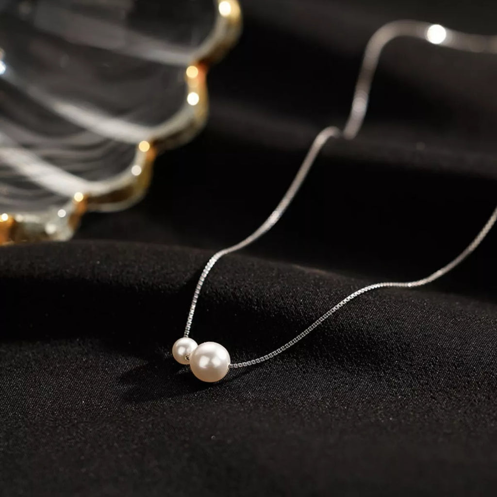 Sterling silver pearl necklace with white pearls and delicate chain, showcasing elegant jewelry design by Shopimist