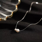 Sterling silver pearl necklace with white pearls and delicate chain, showcasing elegant jewelry design by Shopimist