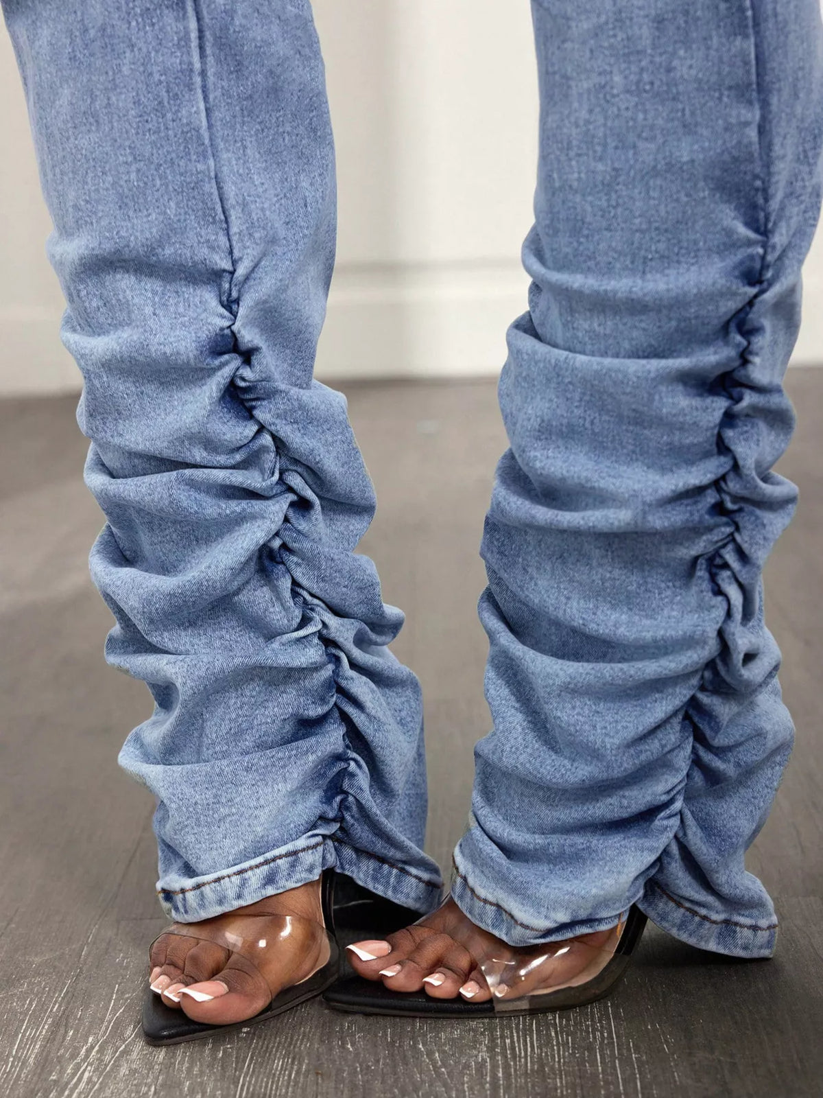 High-waisted distressed stacked hem jeans by Trendsi, featuring a fitted silhouette and frayed detailing on the hem.