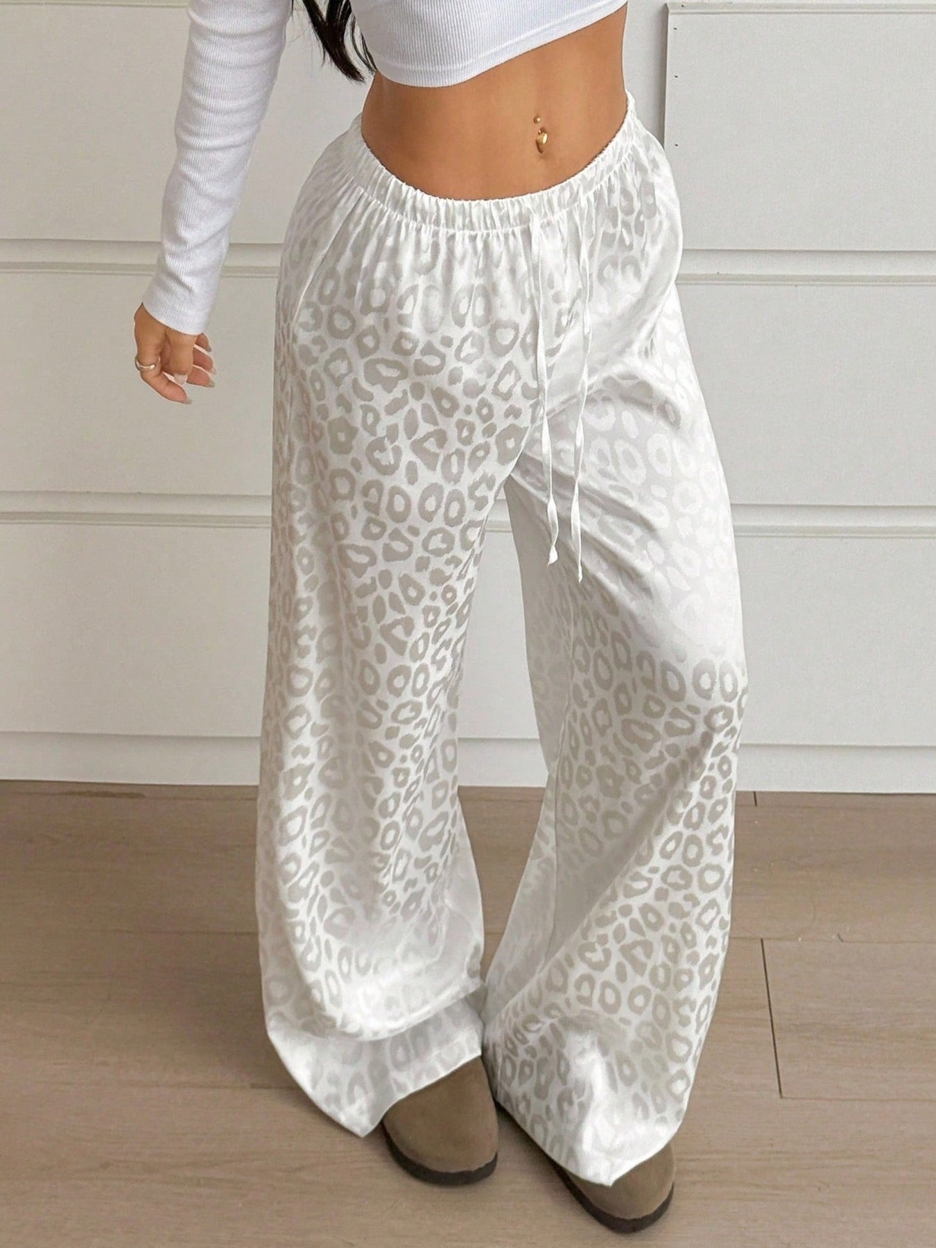 Women's leopard print wide-leg trousers with adjustable drawstring waist from Trendsi, featuring a comfortable fit and stylish animal print.
