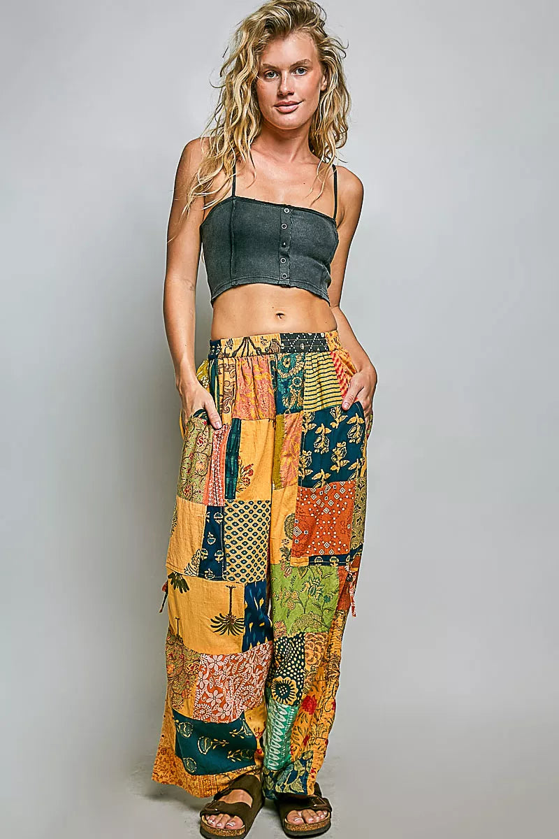 Printed patchwork wide leg cotton pants with side drawstring, styled as a casual dress with colorful fabric patterns.