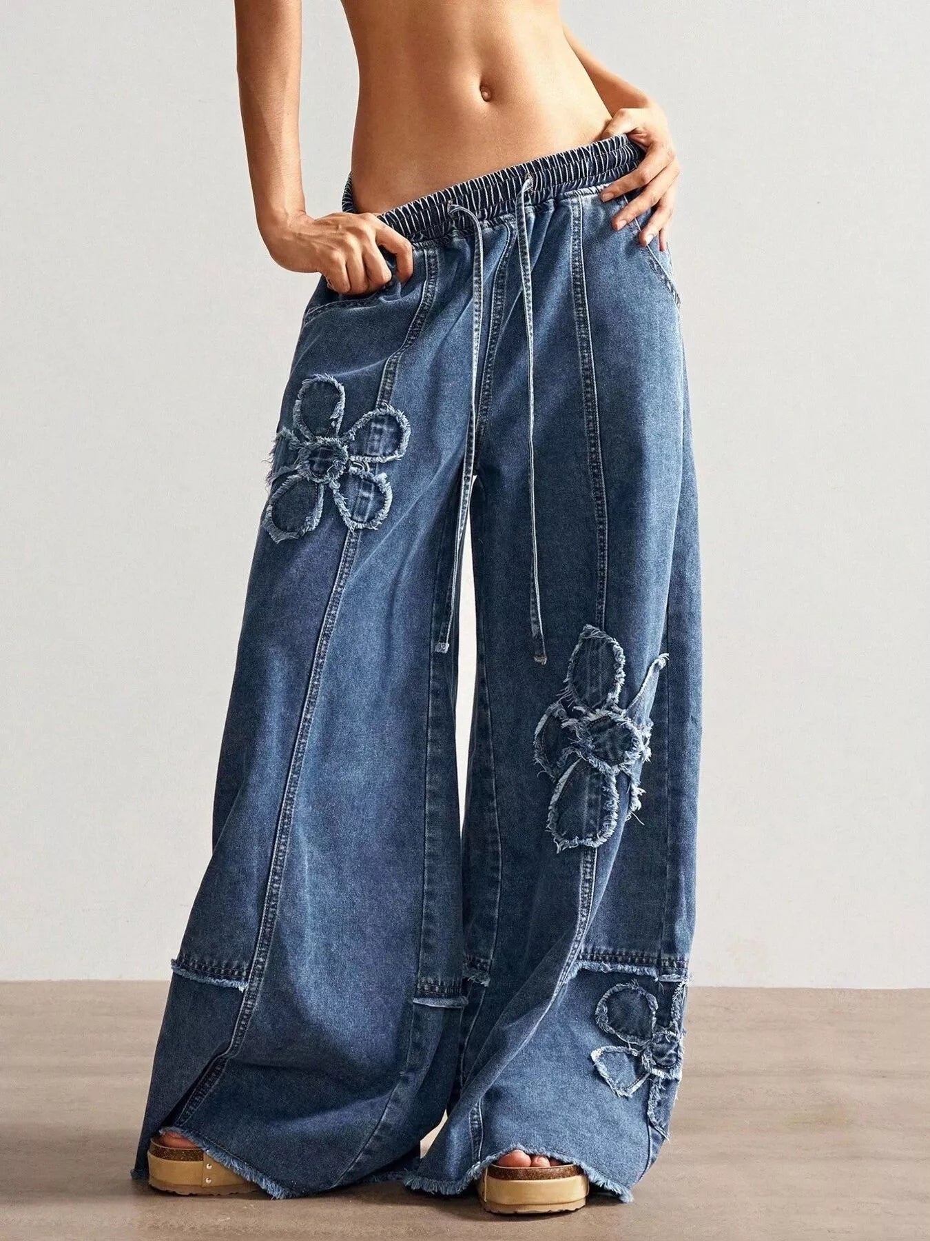 Wide leg jeans with floral appliques from Shopimist, featuring embroidered flower details on denim fabric.