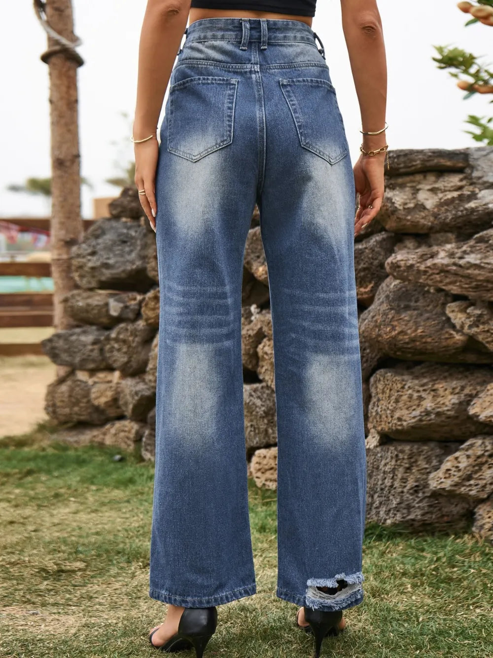 Distressed Plush Fashion Shop denim jeans with ripped details and front pockets, shown on a model.