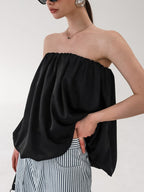 Women's strapless bubble hem tube top by Plush Fashion Hub, sleek minimalist crop top with a fitted silhouette and trendy style.