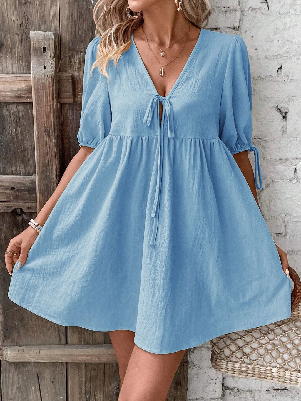 Cotton V-neck tie-front mini dress with puff sleeves from Trendsi, featuring a stylish and breathable design perfect for warm weather.
