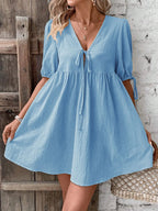 Cotton V-neck tie-front mini dress with puff sleeves from Trendsi, featuring a stylish and breathable design perfect for warm weather.