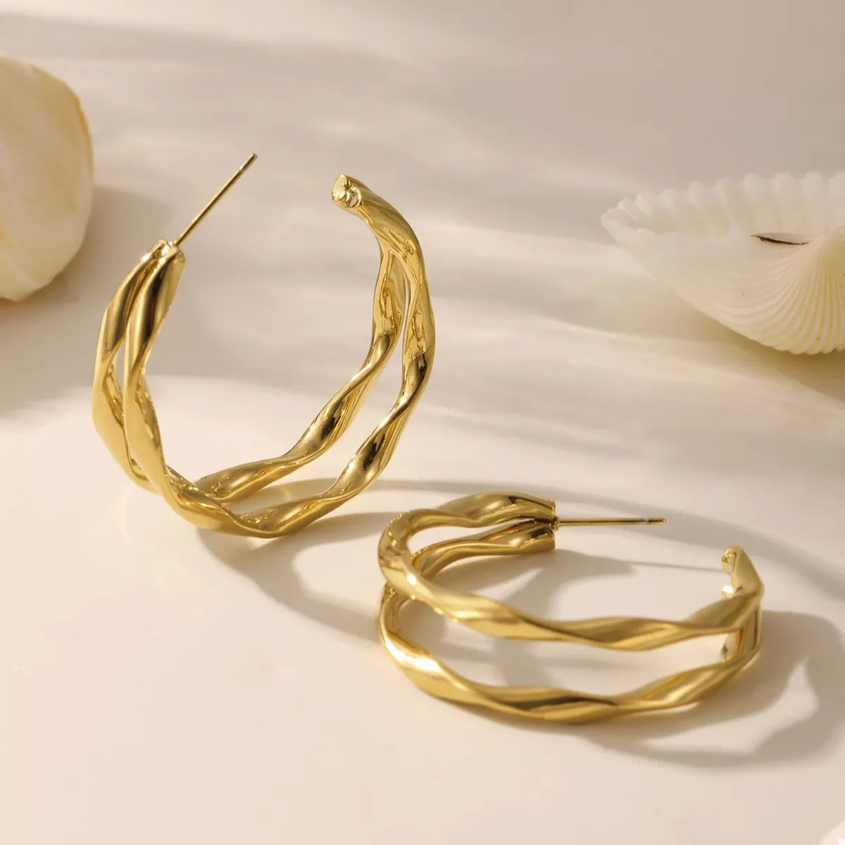 18K gold-plated chunky twisted hoop earrings with bold design, showcasing shiny twisted hoops in a close-up image.