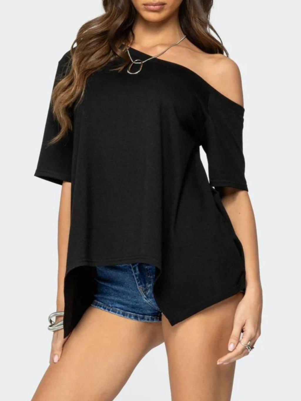 Women's off-shoulder asymmetrical flowy T-shirt from Trendsi, featuring a relaxed fit and stylish design, shown on a model.