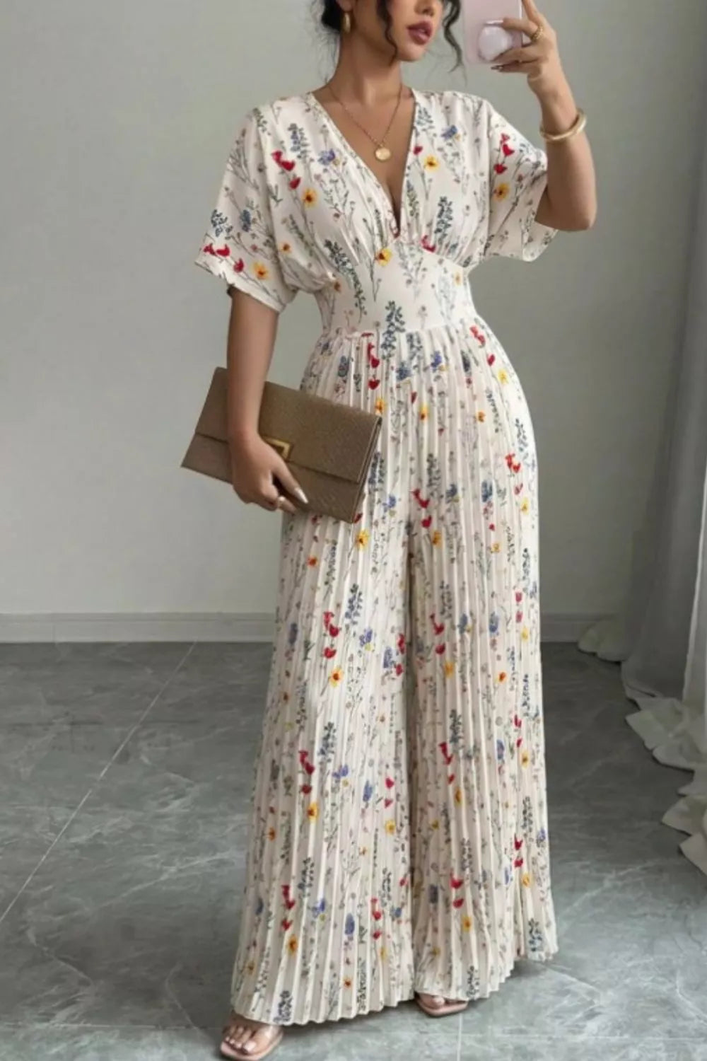 Floral print wide leg pleated jumpsuit by Trendsi featuring a fitted bodice, flowing wide legs, and elegant pleats.