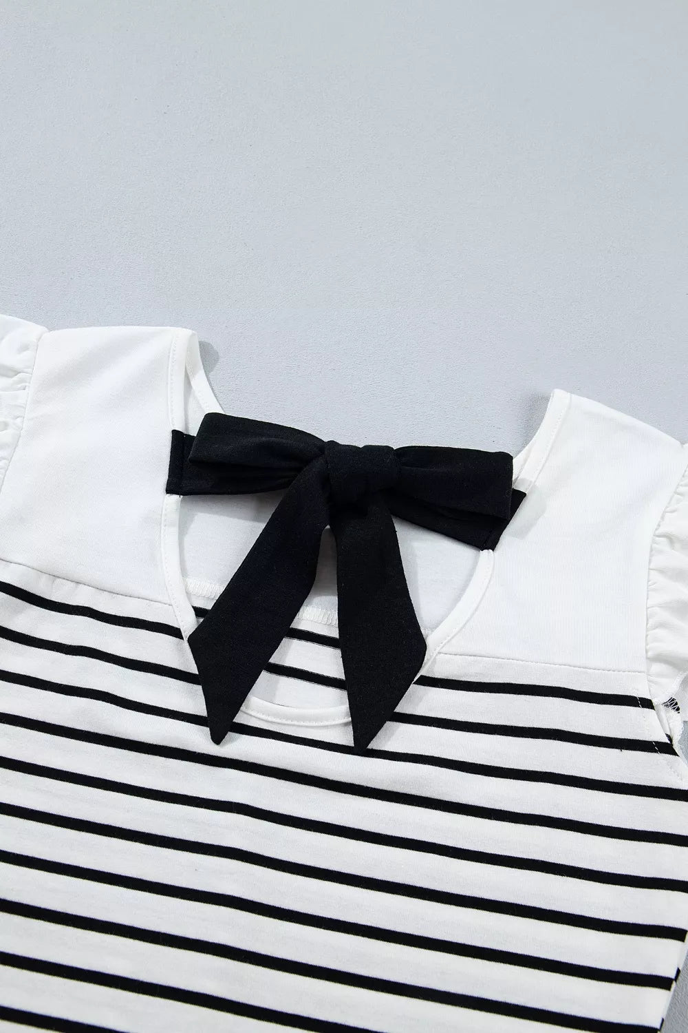 Plush Fashion Hub stripe contrast knot back ruffle trim tank top displayed on a mannequin, showcasing stylish design and details.