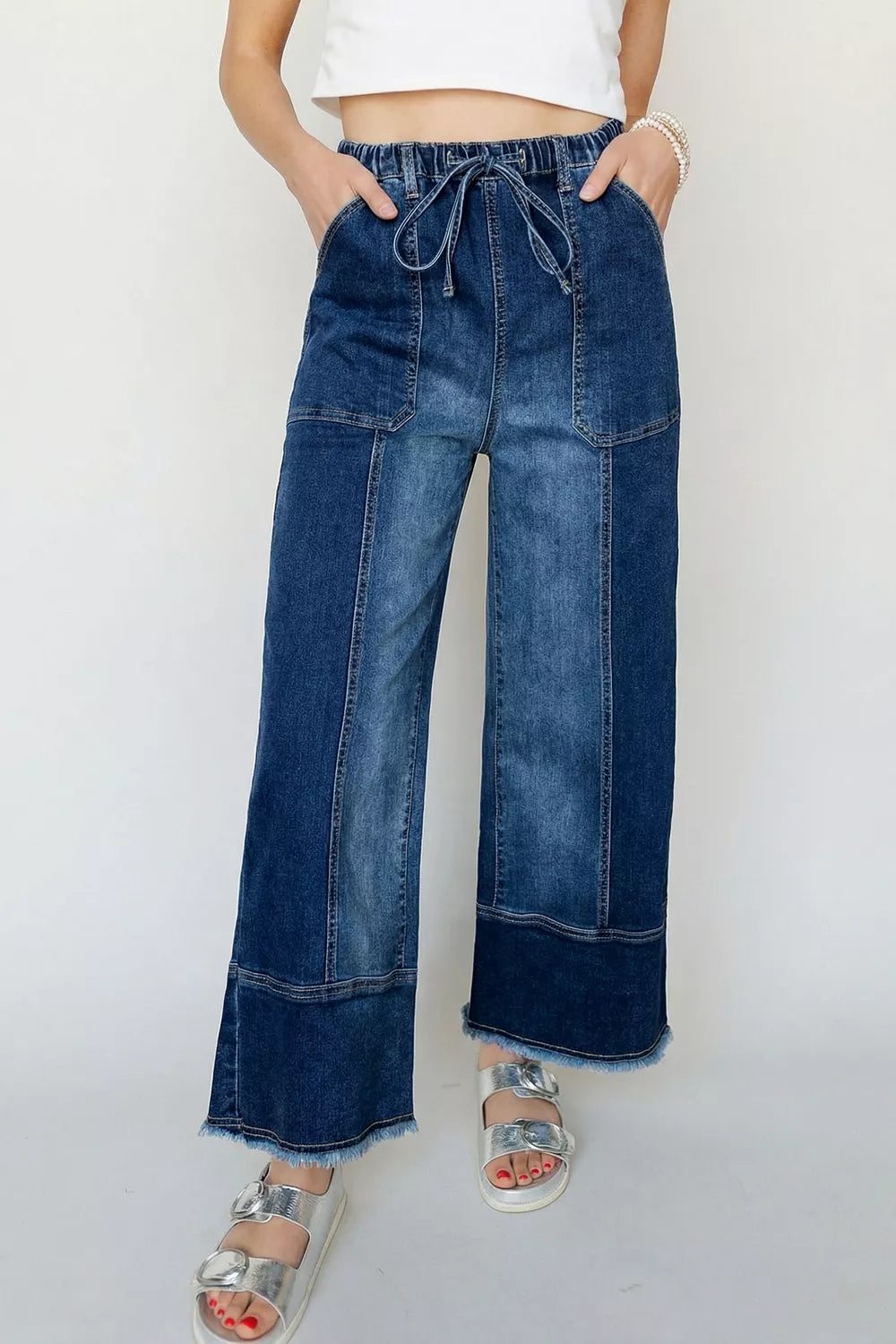 Wide-leg denim pants with drawstring waist, seam details, and raw hem from Plush Fashion Hub, shown on a model.