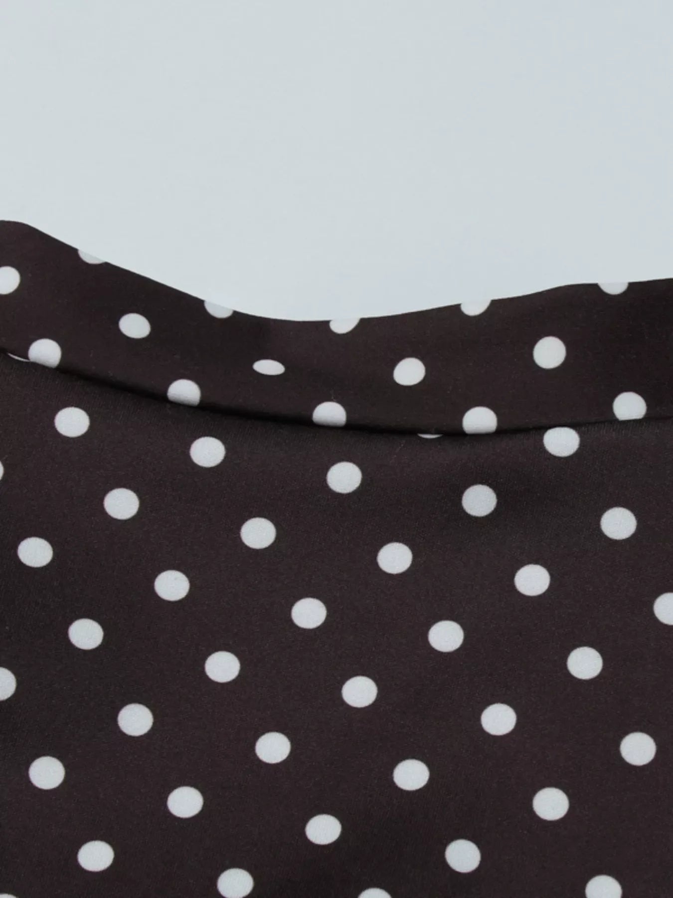 Polka dot cut-out front mini dress by Shopimist featuring a stylish design with a fitted silhouette and playful polka dot pattern.
