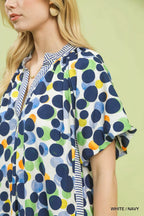 Polka dot print Umgee tunic dress featuring a relaxed fit and long sleeves, displayed on a hanger against a neutral background.