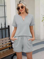 Solid color short sleeve top and shorts two-piece set by Trendsi, casual summer outfit with comfortable fabric and relaxed fit.